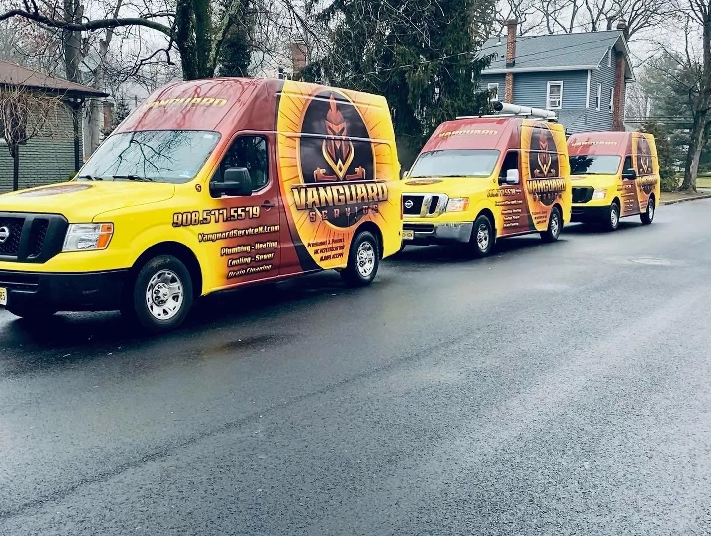 Vanguard Service NJ service vans lined up on a wet street
